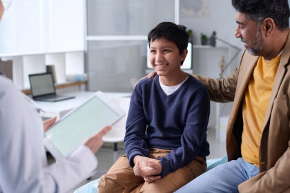 Doctor consults with a boy and his father about AlphaNine SD and hemophilia