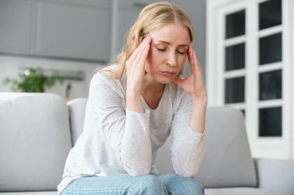 Patient suffering from headache, a side effect of using Alymsys