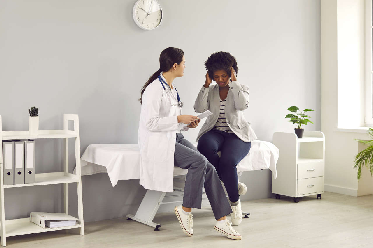Patient with headache from brain tumor talking to a doctor about lomustine
