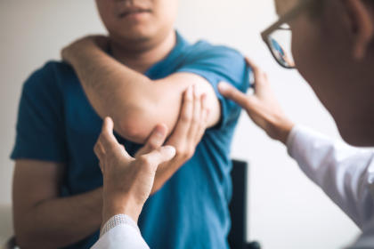 Patient holding arm due to pain, a common side effect of Rixubis