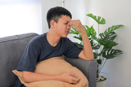 Boy suffering from headaches, a side effect of taking Xyntha