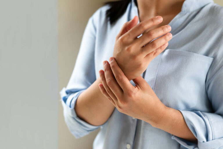 Female patient rubbing wrist due to rheumatoid arthritis, a condition treated by Ixifi
