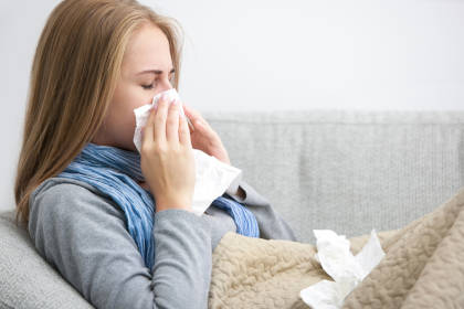 Patient blowing nose due to a stuffy nose, which is a side effect of taking Remicade